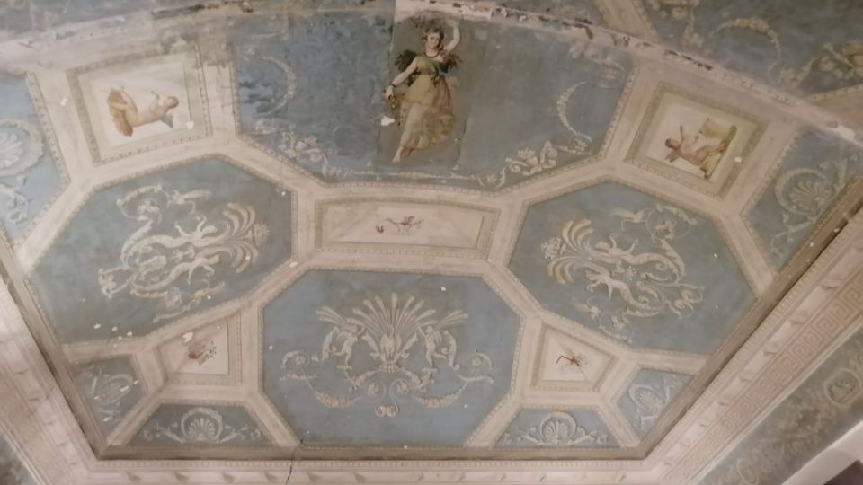 Soffitto interno decorato con riquadri ottagonali azzurri e cornici in stucco, con affreschi ornamentali e piccole scene figurative al centro e negli angoli. Intorno corre una fascia perimetrale con motivi geometrici e fregi classici.